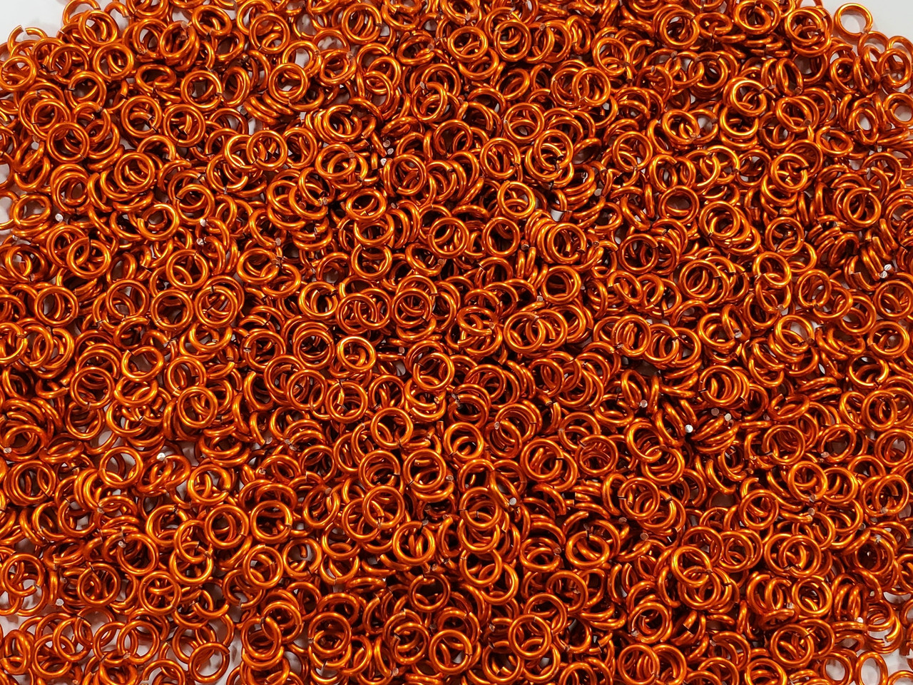 Orange Anodized Aluminum jump rings in 16 SWG, 7/32 inch ID, 1/2 lb (8 oz)